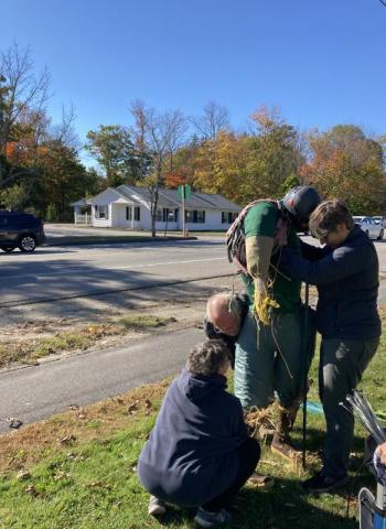 Leslie Hunter left, husband Loren and Mary Beth Brandt work to get Chewonki Foundation’s scarecrow on a pole. EDNA MILLER/Wiscasset Newspaper