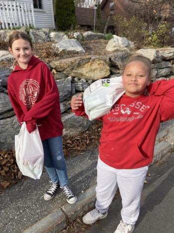 Fifth graders Alex Herrick, left, and Tayia Wright carry
donated food. EDNA MILLER/Wiscasset Newspaper