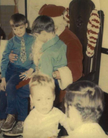 Commissioner Randall Liberty as a boy, visiting his father in prison on Christmas Day. In the photo Liberty sits on Santa’s lap facing the camera. His brother is sitting next to him. Photo supplied by Randall Liberty.