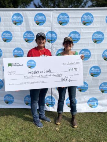 Becky Winslow from Gorham Savings Bank, left, presents a check to Erica Berman at the Maine Marathon. Nayara Dalossi photo