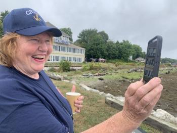 Susan Johns won a third place award for her photo of Jan Flowers looking at a virtual image on her cell phone of Wiscasset’s former schooners, Hesper and Luther Little, during Schoonerfest 2022. File photo