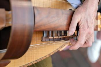 As demonstrated by hurdy-gurdy musician Laurie Rousseau, the instrument has a keyboard, melody and drone strings, and a hand-cranked wheel to make the music. Bob Bond/40 Federal Studio