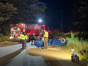 Lincoln County Sheriff’s Office accident reconstruction team members inspect the overturned Porsche on Back Narrows Road on Friday, July 19. Mark Sullivan photo