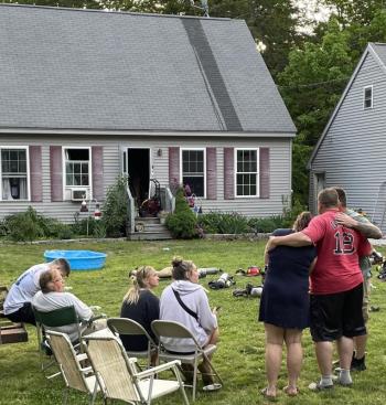 Ed Crocker, in red, holds wife Candie at the scene of the fire that heavily damaged their home. FRITZ FREUDENBERGER/Boothbay Register