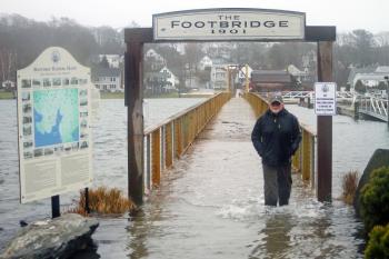 Dick Morrison crosses the flooded footbridge during a January storm. STEVE EDWARDS/Boothbay Register