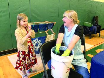 Indigo Sanders-Stoyle, 7, of Wiscasset watches artist Emily Bell-Hoerth dip and dye in indigo at Wiscasset’s Earth Day celebration at Wiscasset Community Center April 27. SUSAN JOHNS/Wiscasset Newspaper 