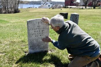 Steve Christiansen examines the headstone of Ezekiel Averill remembered for having served as a body guard to George Washington during the American Revolution. PHIL DI VECE/Wiscasset Newspaper
