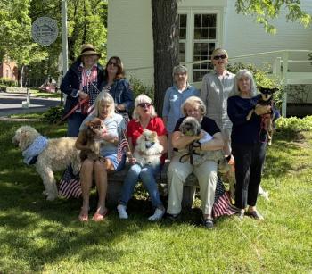 The Fundraising Committee of the Friends of the Wiscasset Public Library meet to plan Bands for Books.  First row from left: Cynthia Davis (with Quincy), Linda Adams (with Finnegan), Lynn Maloney (with Bradley), and Linda Smith (with Ginger). Second row from left:  Michelle Wentworth (with Sandy), Tracey Whitney, Stephanie Hergenroeder, and Laura Neebling (with Roland). Bill Maloney photo