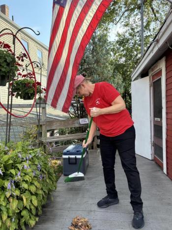 Red’s Eats employee Sandy Craig sweeps away leaves  at the internationally famous Wiscasset stand before it opens for the day Oct. 2. SUSAN JOHNS/Wiscasset Newspaper 