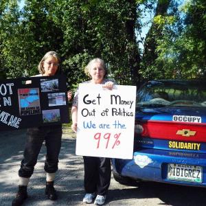Occupy Maine supporters Jenny Gray, left, and Patricia Messier hold signs they will be displaying at Bank of America in Brunswick on Aug. 4. CHARLOTTE BOYNTON/Wiscasset Newspaper Occupy Maine, Jenny Gray, Patricia Messier, Bank of America