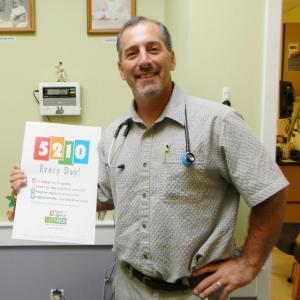 Dr. Steven Feder is one of 200 pediatricians in Maine to receive an award for a childhood obesity prevention program, among other initiatives. The 5-2-1-0 program is so popular that many states have sought to use the campaign. Feder stands in his office at the John F. Andrews Medical Arts building in Boothbay Harbor, holding one of the catchy posters distributed throughout the nation to promote healthy families. DIANE RANDLETT/Boothbay Register