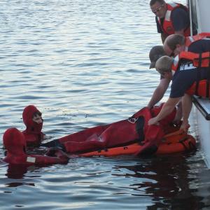 Members of the Wiscasset Fire Department, clad in bright red Gumby suits, conduct a water rescue training exercise on the town's waterfront August 22. JOHN MAGUIRE/Wiscasset Newspaper