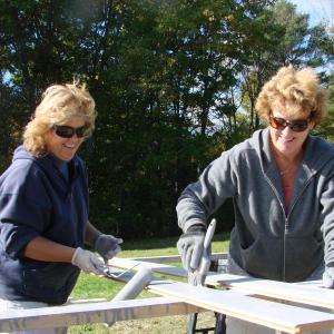 Wendy Caron, left, of Boothbay Harbor and Michelle Peele have fun working at the site of a riverside barn, at Peele's Marianmade Farm in Wiscasset. SUSAN JOHNS/Wiscasset Newspaper 