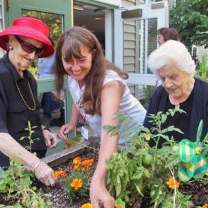 Marie Callnan (on left), Gregory Wing Activities Director Jerie Phinney, and Veula Reed (on right) work in one of the raised bed gardens outside the Gregory Wing at St. Andrews Village. A new garden made possible by the St. Andrews Hospital Auxiliary will make it easier for more residents to enjoy the outdoors in an unstructured but secure atmosphere. The new garden features a walkway, patio and wooden fence. Courtesy of Lincoln County Healthcare