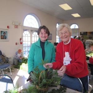 Garden Club of Wiscasset members, Judy Hughes (left) and Anne Smith arrange greens and berries in baskets to be delivered to area residents. Courtesy of the Garden Club of Wiscasset