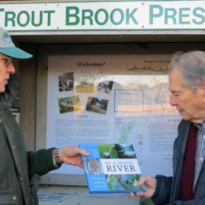 SVCA president John Atwood presents Roy Farmer with a “By a Maine River” book as a token of thanks for his years of service to the association. Courtesy of Sheepscot Valley Conservation Association
