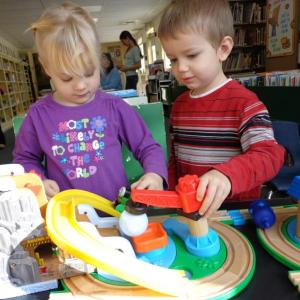 Grace Segerstrom and J. J. Pray enjoy the train and tracks set donated to the Wiscasset Public Library Children’s Room by Papa Geppetto’s Workshop. Courtesy of Wiscasset Public Library