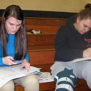 Juniors Abby Dunn, left, and Hannah Campbell work to figure out their future "financial fitness" using the materials and information provided by Maine's Credit Unions. Courtesy of Wiscasset High School