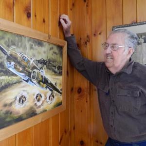 George Jones looks at a painting that hangs in his Wiscasset home: a B-25 on a low flying bombing mission. The painting was done for him by a friend. CHARLOTTE BOYNTON/Wiscasset Newspaper