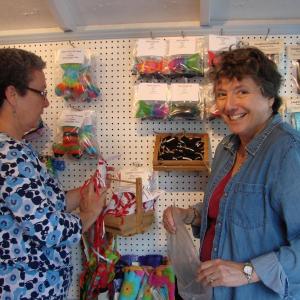 Linda Estabrook, left, and Pam Shockley help set up the Maine Craft Shack on the creamery pier on the waterfront in Wiscasset May 20. Estabrook, Shockley and three other women have a cooperative through which several other crafters' items are also sold. The shack opens Friday, May 24. SUSAN JOHNS/Wiscasset Newspaper