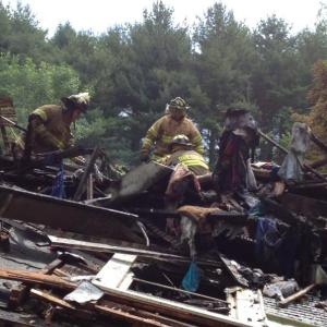 Dresden and Richmond firefighters sort through debris June 30 following a rekindle of the fire that destroyed this Cedar Grove Road, Dresden, home a day earlier. SUSAN JOHNS/Wiscasset Newspaper