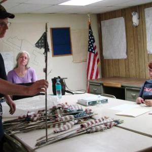 Edgecomb Fire Chief Roy Potter holds up one of the fragmented flags he found at a cemetery Memorial Day morning. Also pictured are selectmen's secretary Jen Elkins, left, and Selectman Jessica Chubbuck. SUSAN JOHNS/Wiscasset Newspaper