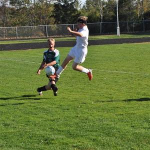 Aidan Carlson, right, grabs some air as he pursues the ball and a Spruce Mountain player. BEN BULKELEY/Wiscasset Newspaper
