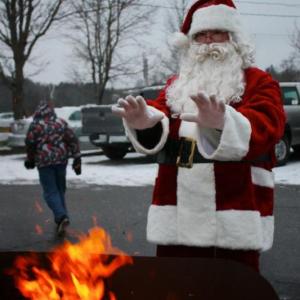 Santa warms his gloved hands at a 2012 holiday event. Courtesy of Wiscasset Area Chamber of Commerce