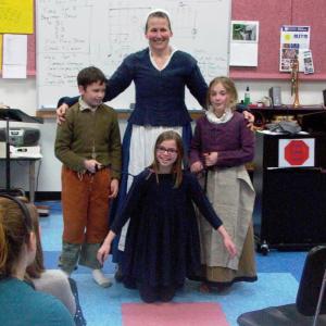 Plimoth Plantation Living History presenter Vicki Oman demonstrates clothing from the early 17th century with the help of Bristol School fifth and sixth graders, prior to their Colonial Overnight visit to Plimoth Plantation. Students are, from left, Dawson Wall, Liza Cheney and Madison Opert. Courtesy of Peggy Farrell