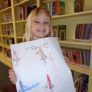 Grace holds up her finished pictures.