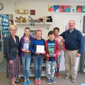 Maryanne Ward, left, member of the Maine Humanities Council board of directors, with sixth graders, from left, Sydney Sullivan, Kate Larson, Zak Bhe, and Nicco Bartone with the books that inspired their Letters about Literature. At right is their teacher, Glenn Powers. Courtesy of Krista Woodbridge