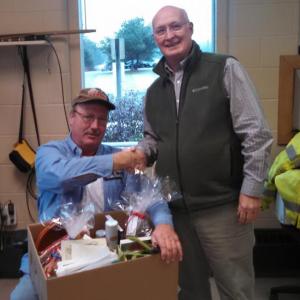 PETER WILLIAMS presents the gift basket to John Orne at his Water District office on Tuesday morning. Courtesy of Peter Williams