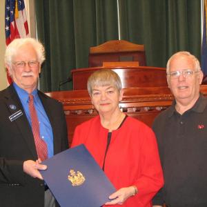 Rep. Bruce MacDonald presents Lincoln County TRIAD chairman and Boothbay Harbor resident Debbie Mullen with a special legislative sentiment in the State House in March of 2010. Mullen was joined by then TRIAD Vice Chairman Dwight Lewis of Southport. File photo