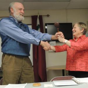 New Lincoln County Democrats Chairman Jim Torbert accepts the gavel from retiring Chairman Lisa Miller. Courtesy of Tom Eichler