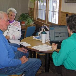 Volunteer AARP Tax Preparation Supervisor Marilynn Wilson (back to) assists a consumer with her taxes. Courtesy of Marianne H. Pinkham