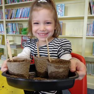 Addison West shows her seedlings in biodegradable cups ready for warm weather. Courtesy of Natalie Castonia