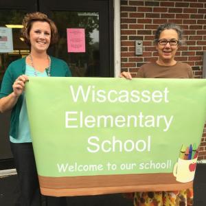 Wiscasset Superintendent of Schools Heather Wilmot, left, and Wiscasset Elementary School Principal Mona Schlein on Monday hold the sign that will greet students and others Aug. 31 when school opens at the former Wiscasset Middle School. Work is under way on the school’s new permanent sign. SUSAN JOHNS/Wiscasset Newspaper Wiscasset Superintendent of Schools Heather Wilmot, Wiscasset Elementary School Principal Mona Schlein