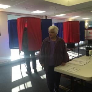 Katharine Martin-Savage speaks with a fellow ballot clerk. Behind her, a Wiscasset resident votes in a booth at Wiscasset Community Center on Tuesday morning. SUSAN JOHNS/Wiscasset Newspaper