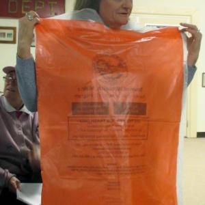 A woman in Woolwich holds up a bag that was Woolwich’s new way of trash disposal, prior to Tuesday’s election that turned around a town meeting vote favoring pay-as-you throw. File photo