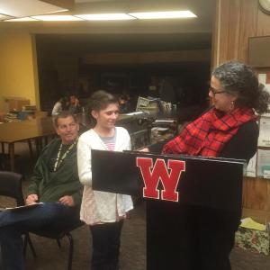 Wiscasset schools’ maintenance and transportation director John Merry looks on as Wiscasset Elementary School fifth-grader Mae Benner accepts a November student-of-the-month honor from WES Principal Mona Schein, Dec.17 at Wiscasset Middle High School. SUSAN JOHNS/Wiscasset Newspaper