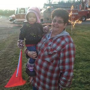 Debbie Ethier of Wiscasset and granddaughter Lyla Reed, with a red flag for Christmas, await the passing of trucks carrying wreaths bound for Virginia. SUSAN JOHNS/Wiscasset Newspaper