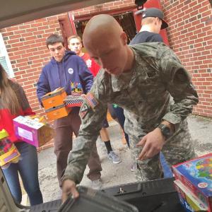 Wiscasset Middle High School sophomore Lindsey Gordon, followed by senior Alex Webber and junior Grant Hefler help Brandon Keene of Maine Army National Guard’s 133rd Engineering Battalion load gifts into a vehicle Dec. 18. SUSAN JOHNS/Wiscasset Newspaper