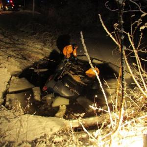 First responders attempt a rescue of Edward MacDonald, 67, of Woolwich after his vehicle slid from Route 27 and came to rest on its roof in this small pond in Pittston. Photo by Maine State Police Trooper Klayton Peckham