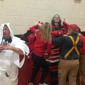 WGME’s Jeff Peterson carries on, wrapped in tissue, as Allen Cohen and others help WMHS Principal Peg Armstrong down from the gym wall where students taped her. SUSAN JOHNS/Wiscasset Newspaper
