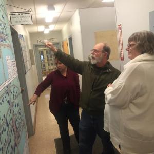 In the municipal building hallway April 7, Wiscasset Historic Preservation Commission members, from left, Wendy Donovan, Gordon Kontrath and Susan Blagden look over the state’s concepts for downtown changes. SUSAN JOHNS/Wiscasset Newspaper