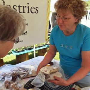 Beryl waits on one in the long line of pastry lovers who line up at her stand every Thursday at the Boothbay Farmers’ Market. SUZI THAYER/Boothbay Register
