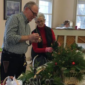 Carol Blake is at the piano at the Garden Club of Wiscasset’s December meeting as Tom Cramer, Linda Belmont and club members make holiday baskets for community and town organizations and assisted care homes. Courtesy photo