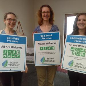 Midcoast Conservancey staff, from left, Hannah Chamberlain and Anna Fiedler, and MCC steward Jess Richards show off the new preserve signs. Courtesy photo