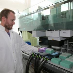 Brian Thompson, a research associate in the Single Cell Genomics Center at Bigelow Laboratory for Ocean Sciences, loads samples into a liquid handling robot. The Laboratory recently published the details of significant advances in single cell genomics technology, which allows scientists to study the genes of individual cells. Courtesy of Bigelow Laboratory