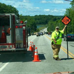 Roland Abbott of Edgecomb Fire Department works on traffic at an Aug. 6 accident at Routes 1 and 27. In the background, motorcycles with Stoney’s Memorial Run approach. Courtesy of Edgecomb Fire Department